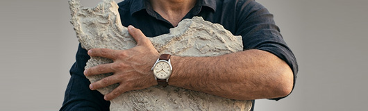 Luxury watch on a man's wrist with dark moody lighting
